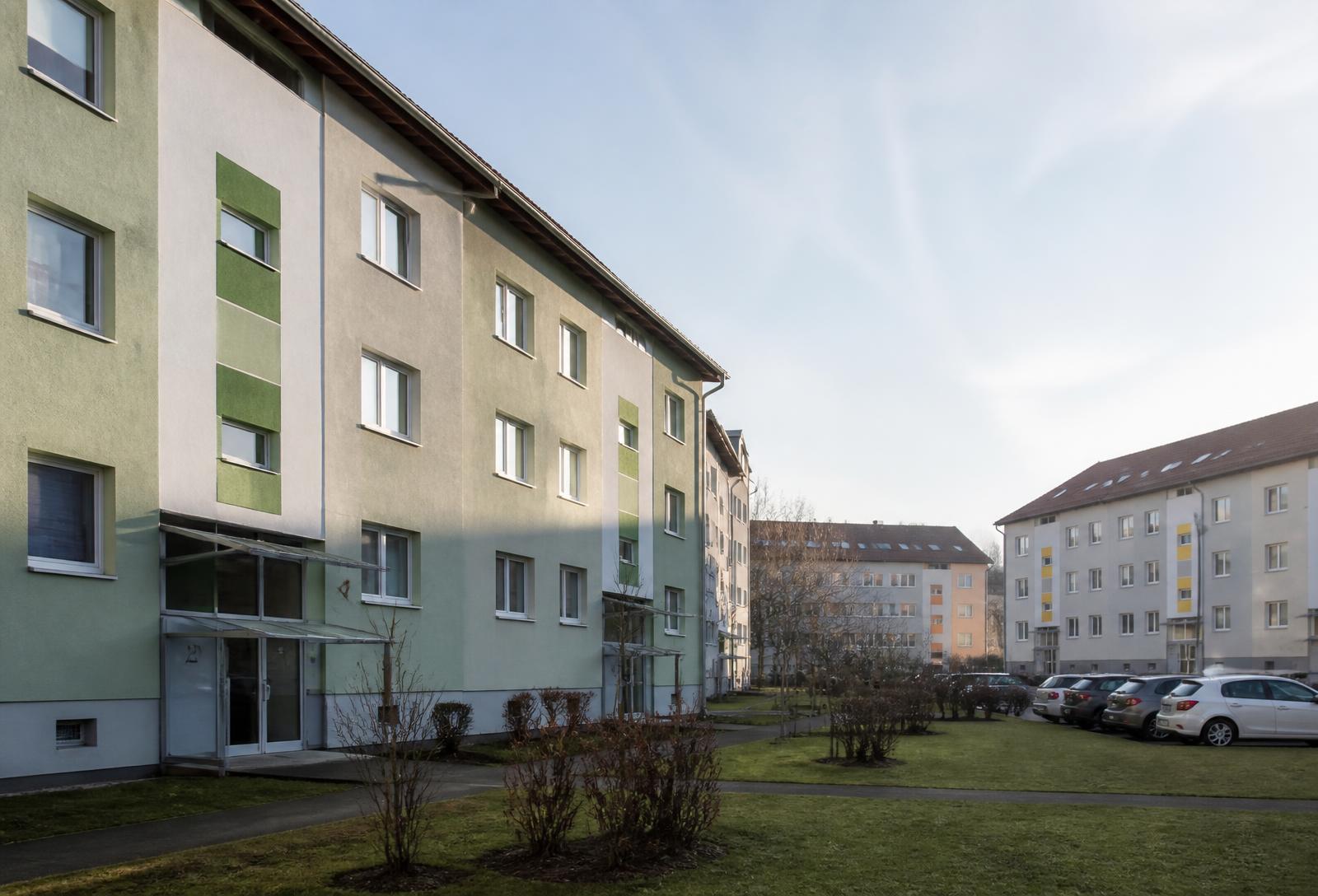 Wohnquartier mit sanierten Mehrfamilienhäusern, Grünflächen und Stellplätzen