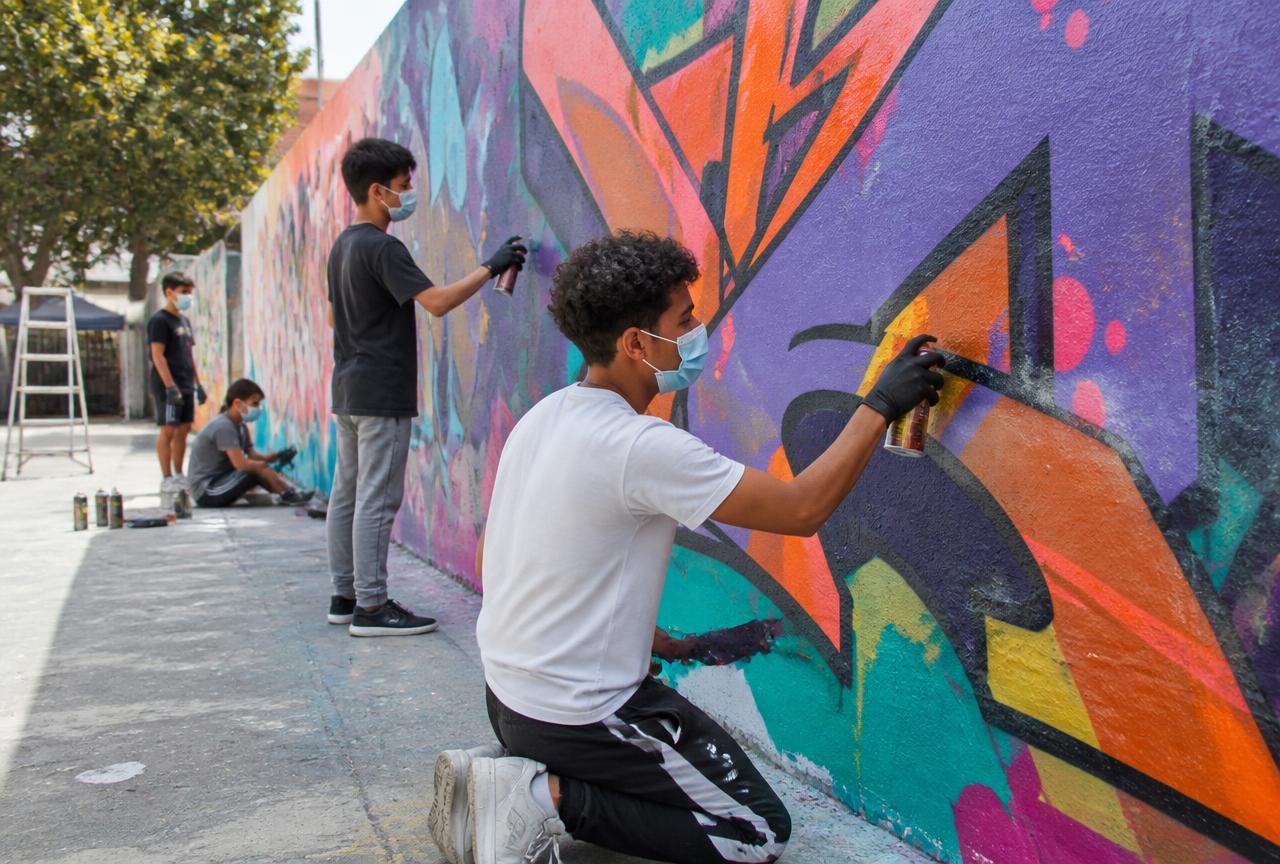 Jugendliche gestalten unter Anleitung eine legale Graffiti-Wand